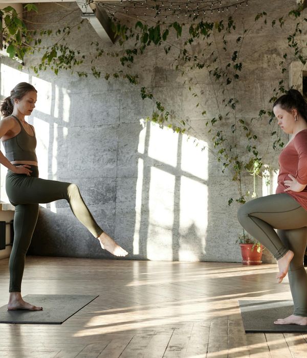 Woman in a calm yoga posture in a dark room with a honey-colored light.